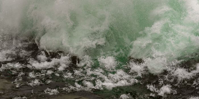 Waves crashing on shore representing natural disasters