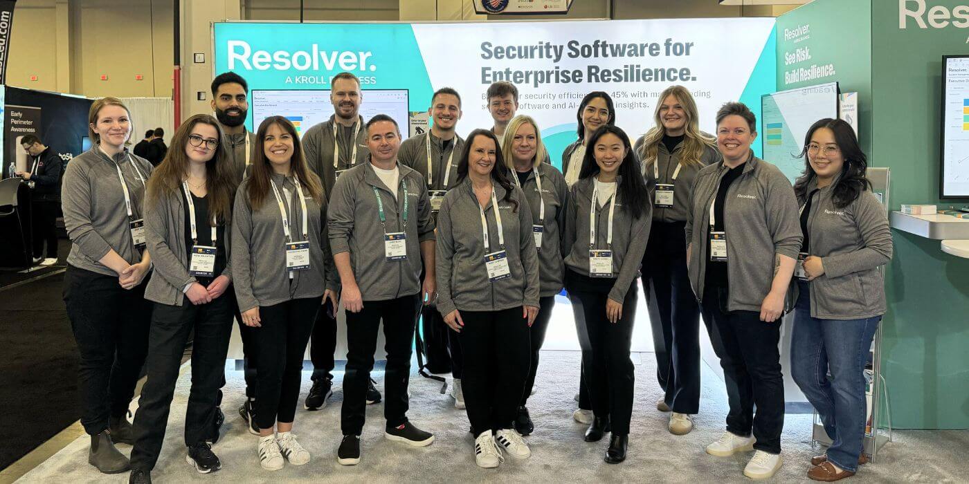 A group photo of the resolver team at isc west 2024, standing in front of the resolver booth showcasing "security software for enterprise resilience. "