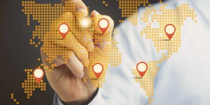 Male hand behind digital map of the world representing international expansion