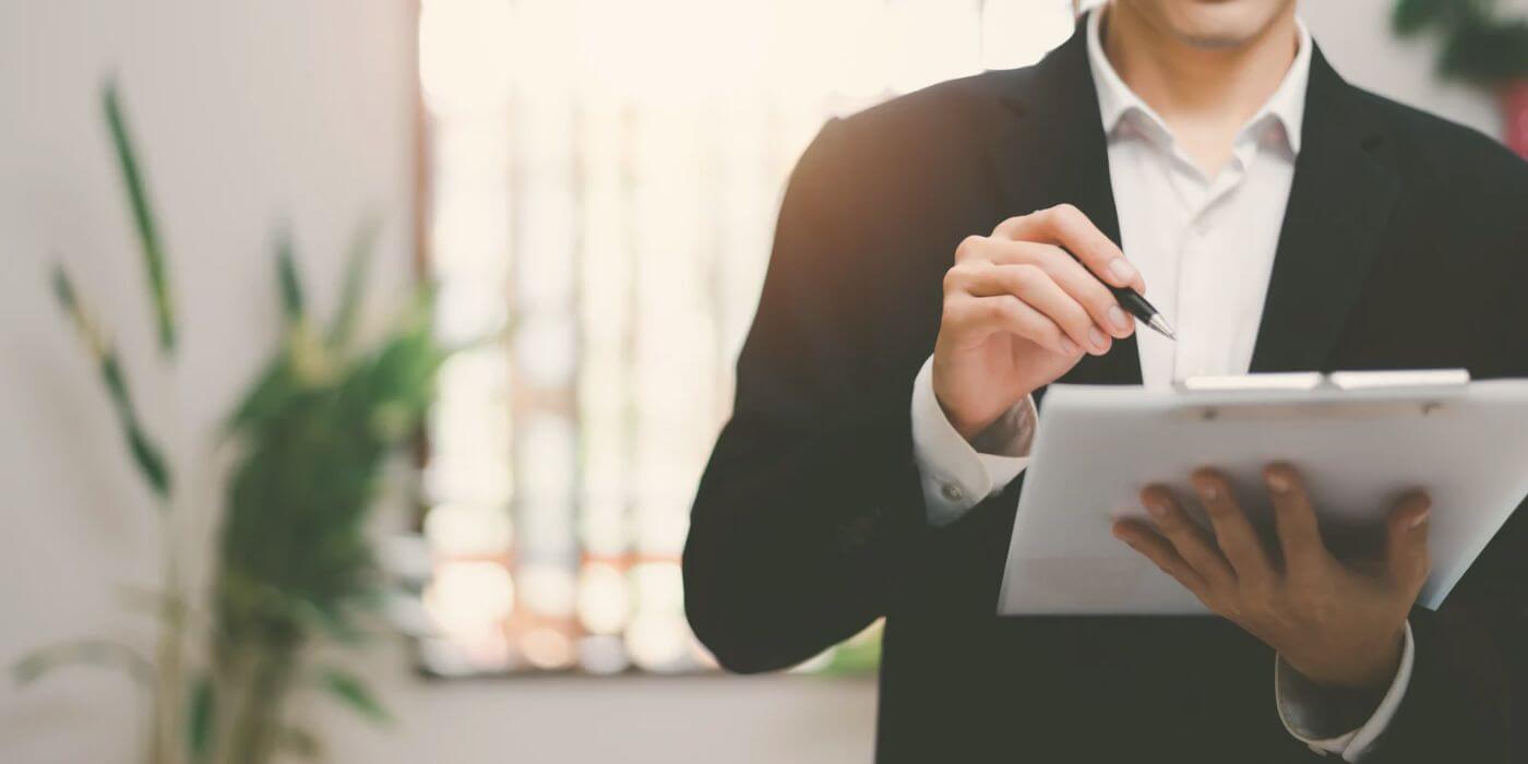 Business professional reviewing a clipboard in an office setting, emphasizing risk control self-assessments (rcsas) in the context of risk management and compliance.