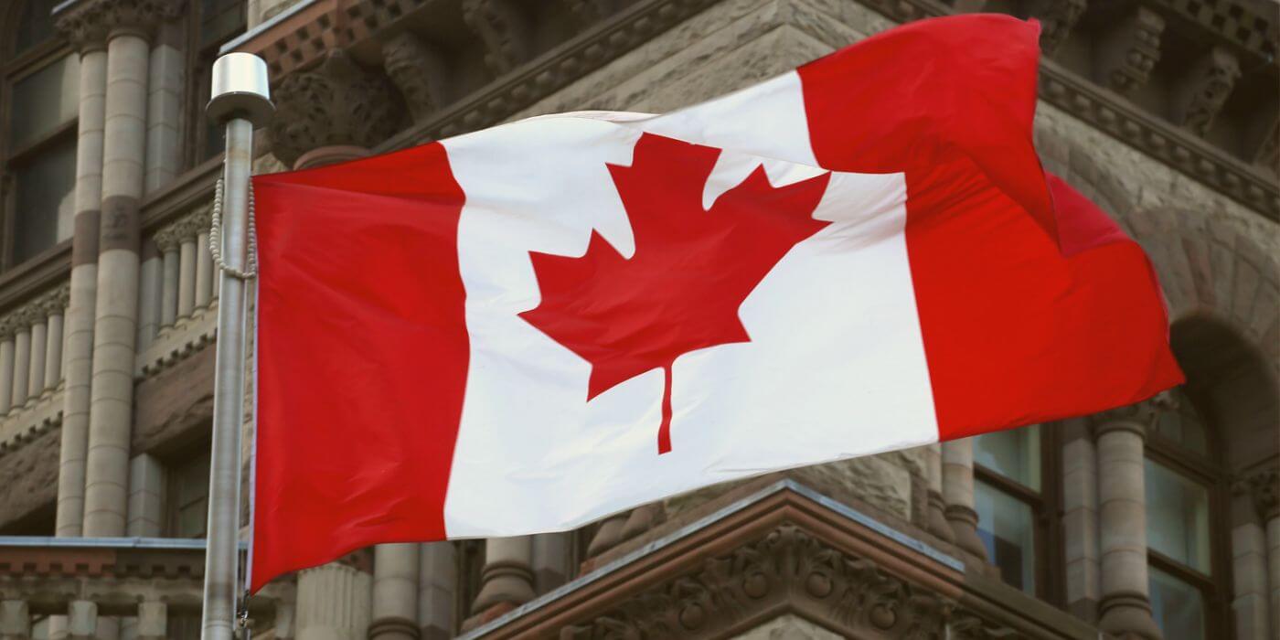 Canadian flag in front of a historic building, representing canadian aml regulatory changes in 2024