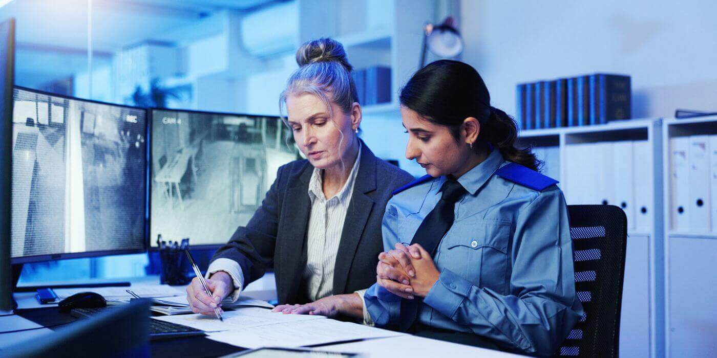 Two security professionals reviewing incident reports in a security operations center, illustrating the need for corporate security sop automation and ai-powered incident management workflows.